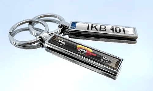 Metal comic keychain with car design and license plate detail