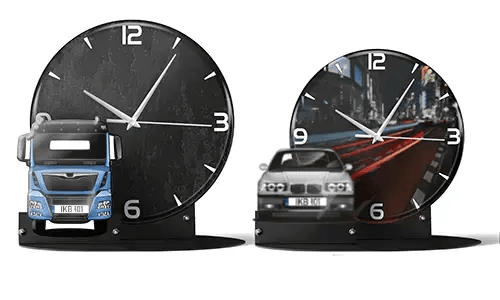 Two decorative clocks with model vehicles: left with black marble face and blue truck, right with cityscape and red sports car