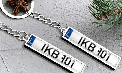 Metalowy brelok z tablicą rejestracyjną i detalem flagi