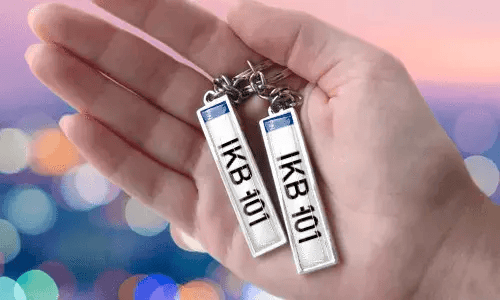 Llaveros con placa personalizada y números personalizados, sostenidos en la mano