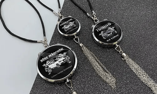 Three black pendants with chains: each with car graphic and German tuning slogan on glittery surface