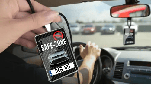 Auto-Safezone-Anhänger mit Carbon Hintergrund in der Hand Auto-Schutzraum-Anhänger